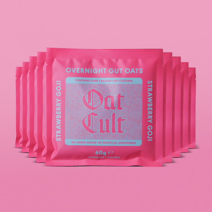 Multiple packages of Oat Cult Overnight Gut Oats strawberry goji on a pink background