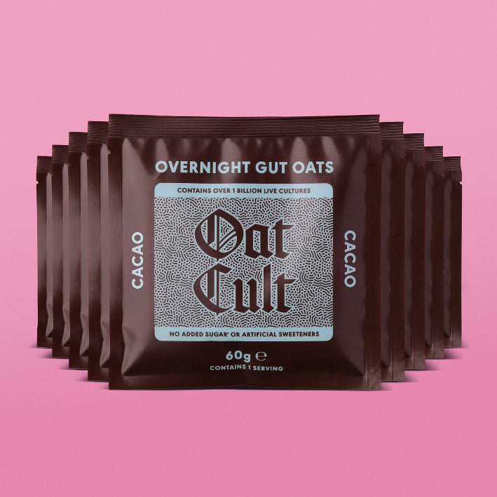 Multiple packages of Oat Cult Overnight Gut Oats cacao on a pink background
